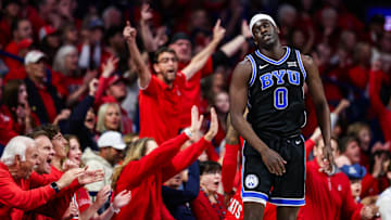 Feb 22, 2025; Tucson, Arizona, USA; BYU Cougars forward Mawot Mag (0) reacts after Arizona Wildcats guard Caleb Love (1) scores a three-point basket during the first half at McKale Center. Mandatory Credit: Aryanna Frank-Imagn Images