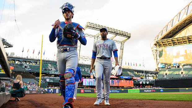 Texas Rangers top prospect Kumar Rocker, right, and catcher Jonah Heim enter the dugout before Rocker's MLB debut in Seattle.