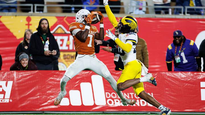 Dec 31, 2025; Orlando, FL, USA; Texas Longhorns wide receiver Kaliq Lockett (7) makes a catch over Michigan Wolverines defensive back Jyaire Hill (20) for touchdown during the second half at Camping World Stadium. Mandatory Credit: Matt Pendleton-Imagn Images
