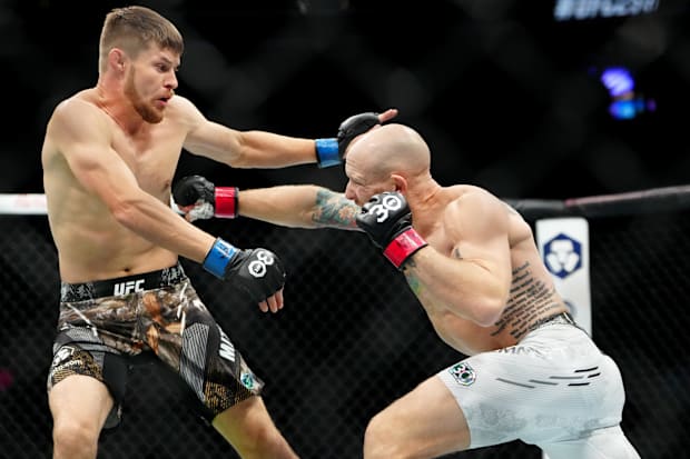 Josh Emmett (red gloves) fights Bryce Mitchell (blue gloves) during UFC 296 at T-Mobile Arena.