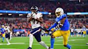Dec 19, 2024; Inglewood, California, USA; Denver Broncos wide receiver Marvin Mims Jr. (19) runs the ball ahead of Los Angeles Chargers safety Derwin James Jr. (3) during the first half at SoFi Stadium.