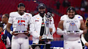 Dec 14, 2024; Atlanta, GA, USA; Jackson State Tigers quarterback Jacobian Morgan (15) and head coach T.C. Taylor and defensive lineman Jeremiah Williams (0) hold trophies after a victory over the South Carolina State Bulldogs in the Celebration Bowl at Mercedes-Benz Stadium. Mandatory Credit: Brett Davis-Imagn Images
