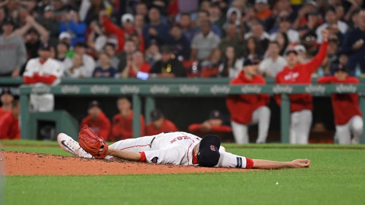 May 14, 2024; Boston, Massachusetts, USA; Boston Red Sox pitcher Chris Martin (55) makes a catch for an out and stays on the ground in pain during the eighth inning against the Tampa Bay Rays at Fenway Park. Mandatory Credit: Eric Canha-USA TODAY Sports