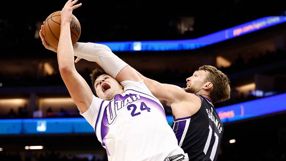 Utah Jazz center Walker Kessler reaches for a rebound against Sacramento Kings center Domantas Sabonis.