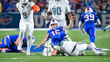 Buffalo Bills punter Cameron Johnston (16) is roughed by Miami Dolphins defensive tackle Zach Sieler (92) resulting in a first down in the fourth quarter at Highmark Stadium.