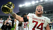 Indiana Hoosiers offensive lineman Bray Lynch (74) holds up the Old Brass Spittoon after beating Michigan State at Spartan Stadium. 