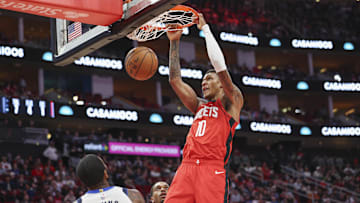 Jan 1, 2025; Houston, Texas, USA; Houston Rockets forward Jabari Smith Jr. (10) dunks the ball as Dallas Mavericks guard Kyrie Irving (11) defends during the first quarter at Toyota Center. Mandatory Credit: Troy Taormina-Imagn Images