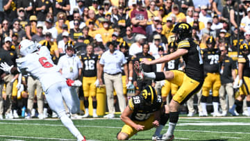 Aug 31, 2024; Iowa City, Iowa, USA; Iowa Hawkeyes place kicker Drew Stevens (18) kicks a field goal as punter Ty Nissen (99) holds and Illinois State Redbirds defensive back Nigel White (6) goes for the block during the first quarter at Kinnick Stadium. Mandatory Credit: Jeffrey Becker-USA TODAY Sports