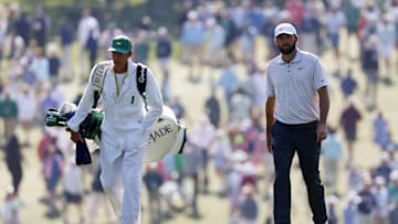 Apr 10, 2025; Augusta, Georgia, USA; Scottie Scheffler and his caddy, Ted Scott, walk along on the first fairway during the first round of the Masters Tournament. Mandatory Credit: Peter Casey-Imagn Images