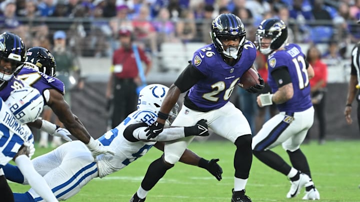 Aug 7, 2025; Baltimore, Maryland, USA; Baltimore Ravens running back Rasheen Ali (26) breaks out of a tackle by Indianapolis Colts defensive end Isaiah Land (55) during the second quarter at M&T Bank Stadium. Mandatory Credit: Rafael Suanes-Imagn Images