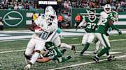 Jan 5, 2025; East Rutherford, New Jersey, USA; Miami Dolphins wide receiver Tyreek Hill (10) is tackled by New York Jets running back Isaiah Davis (32) during a punt return during the first half at MetLife Stadium. Mandatory Credit: Vincent Carchietta-Imagn Images