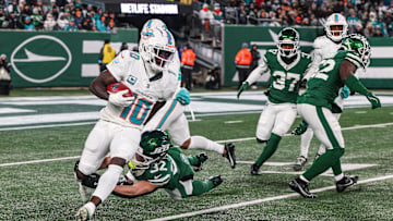 Jan 5, 2025; East Rutherford, New Jersey, USA; Miami Dolphins wide receiver Tyreek Hill (10) is tackled by New York Jets running back Isaiah Davis (32) during a punt return during the first half at MetLife Stadium. Mandatory Credit: Vincent Carchietta-Imagn Images