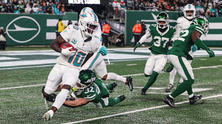 Miami Dolphins wide receiver Tyreek Hill is tackled by New York Jets running back Isaiah Davis during a punt return