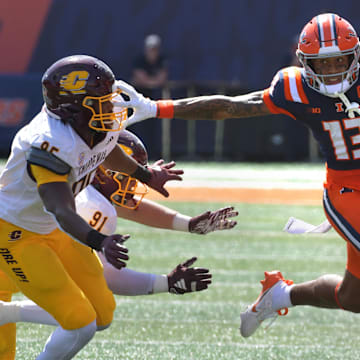 Sep 14, 2024; Champaign, Illinois, USA;  Illinois Fighting Illini wide receiver Pat Bryant (13) stiff arms Central Michigan Chippewas defensive lineman Jaden Davis (95) during the first half at Memorial Stadium. Mandatory Credit: Ron Johnson-Imagn Images