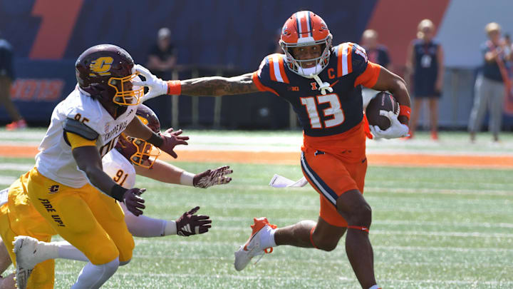 Sep 14, 2024; Champaign, Illinois, USA;  Illinois Fighting Illini wide receiver Pat Bryant (13) stiff arms Central Michigan Chippewas defensive lineman Jaden Davis (95) during the first half at Memorial Stadium. Mandatory Credit: Ron Johnson-Imagn Images