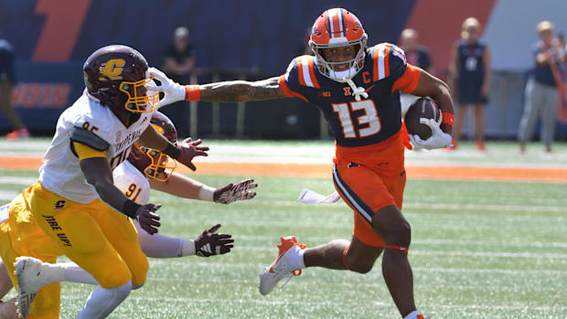 Illinois Fighting Illini wide receiver Pat Bryant (13) stiff arms Central Michigan Chippewas defensive lineman Jaden Davis (9