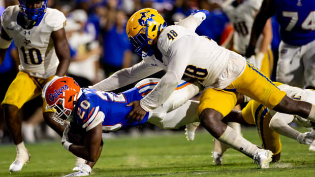 Florida running back Treyaun Webb stretches for a first down tackled by McNeese State linebacker Micah Davey