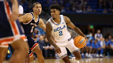 Nov 7, 2025; Los Angeles, California, USA;  UCLA Bruins guard Donovan Dent (2) dribbles the ball around Pepperdine Waves guard Styles Phipps (0) during the first half at Pauley Pavilion presented by Wescom Financial. Mandatory Credit: Kiyoshi Mio-Imagn Images
