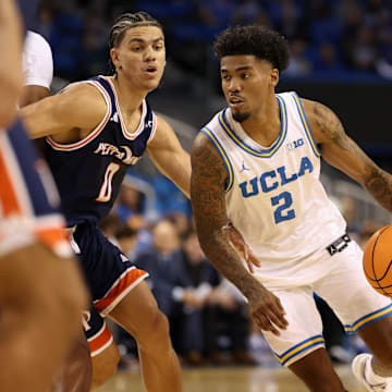 Nov 7, 2025; Los Angeles, California, USA;  UCLA Bruins guard Donovan Dent (2) dribbles the ball around Pepperdine Waves guard Styles Phipps (0) during the first half at Pauley Pavilion presented by Wescom Financial. Mandatory Credit: Kiyoshi Mio-Imagn Images