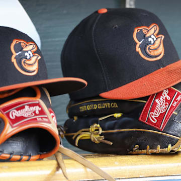 Baltimore Orioles hats and glove sits in dugout