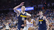 Denver Nuggets center Nikola Jokic (15) defends a drive by Oklahoma City Thunder guard Shai Gilgeous-Alexander.