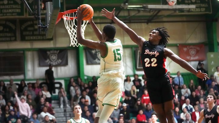 Jan 3, 2024; Phoenix, AZ, USA; St. Mary's Knights Cameron Williams (15) dunks the ball over Brophy Prep Broncos guard Daylen Sharper (22) at St. Mary's High School gym.