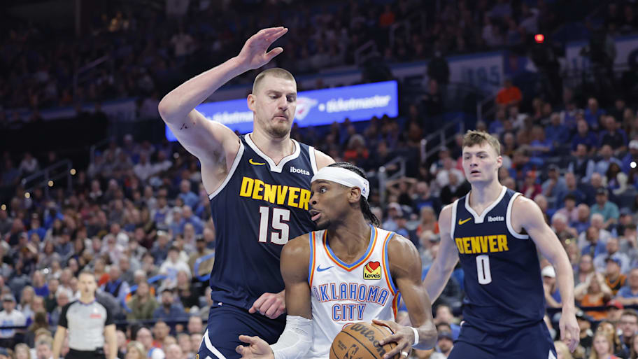 Denver Nuggets center Nikola Jokić defends a drive by Oklahoma City Thunder guard Shai Gilgeous-Alexander.