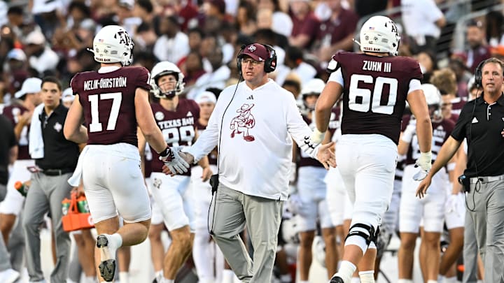 Aug 31, 2024; College Station, Texas, USA; Texas A&M Aggies head coach Mike Elko high fives players as they exit the field during the second quarter against the Notre Dame Fighting Irish at Kyle Field. Mandatory Credit: Maria Lysaker-Imagn Images