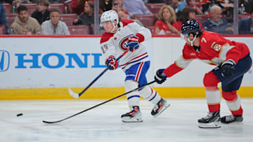 Dec 28, 2024; Sunrise, Florida, USA; Montreal Canadiens right wing Cole Caufield (13) shoots the puck past Florida Panthers defenseman Dmitry Kulikov (7) during the second period at Amerant Bank Arena. Mandatory Credit: Sam Navarro-Imagn Images