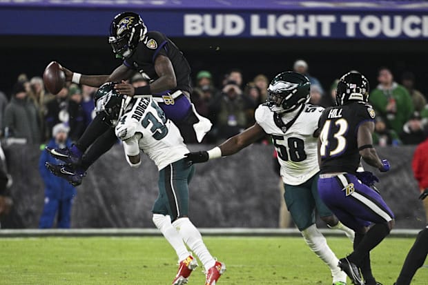 Philadelphia Eagles cornerback Isaiah Rodgers (34) tackles a leaping Baltimore Ravens quarterback Lamar Jackson