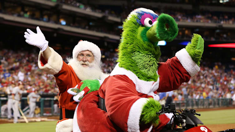 Philadelphia, PA, USA; The Phillie Phanatic gives Santa Claus a ride on his bike