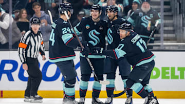 Jan 18, 2025; Seattle, Washington, USA;  Seattle Kraken, from left, defenseman Jamie Oleksiak (24), forward Kaapo Kakko (84), forward Matty Beniers (10) and forward Jaden Schwartz (17) celebrate during the first period against the Los Angeles Kings at Climate Pledge Arena. Mandatory Credit: Stephen Brashear-Imagn Images