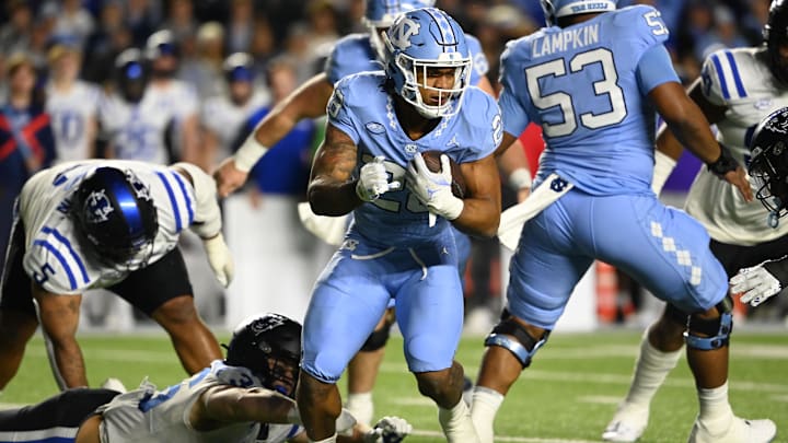 Nov 11, 2023; Chapel Hill, North Carolina, USA; North Carolina Tar Heels running back Omarion Hampton (28) with the ball as Duke Blue Devils linebacker Nick Morris Jr. (36) defends in the first quarter at Kenan Memorial Stadium.  