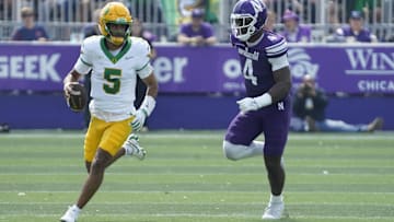 Sep 13, 2025; Evanston, Illinois, USA; Oregon Ducks quarterback Dante Moore (5) runs the ball past Northwestern Wildcats defensive lineman Anto Saka (4) during the first half at Northwestern Medicine Field at Martin Stadium. Mandatory Credit: David Banks-Imagn Images
