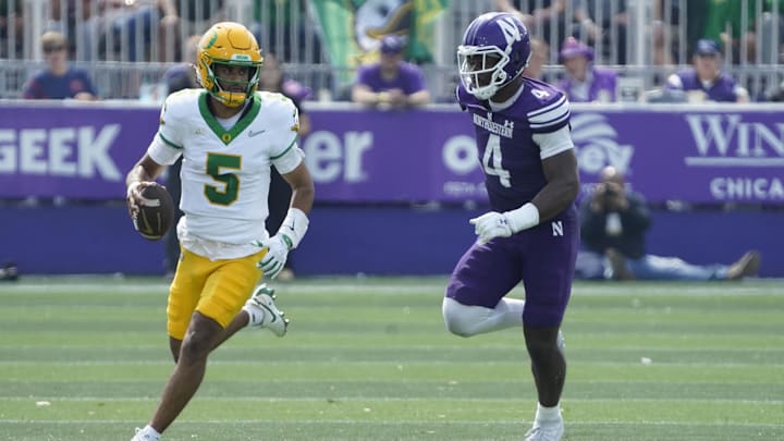 Sep 13, 2025; Evanston, Illinois, USA; Oregon Ducks quarterback Dante Moore (5) runs the ball past Northwestern Wildcats defensive lineman Anto Saka (4) during the first half at Northwestern Medicine Field at Martin Stadium. Mandatory Credit: David Banks-Imagn Images