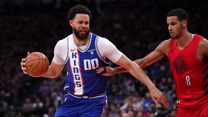 Apr 14, 2024; Sacramento, California, USA; Sacramento Kings center JaVale McGee (00) dribbles the ball next to Portland Trail Blazers forward Kris Murray (8) in the fourth quarter at the Golden 1 Center. Mandatory Credit: Cary Edmondson-USA TODAY Sports