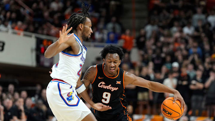 Oklahoma State Cowboys guard Anthony Roy (9) dribbles beside Kansas Jayhawks guard Darryn Peterson (22) during a men's college basketball game between the Oklahoma State Cowboys and the Kansas Jayhawks at Gallagher-Iba Arena in Stillwater, Okla., Wednesday, Feb. 18, 2026.
