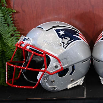 Jan 13, 2025; Foxborough, MA, USA; A pair of New England Patriots helmets sit in front of the podium before a press conference at Gillette Stadium. Mandatory Credit: Eric Canha-Imagn Images