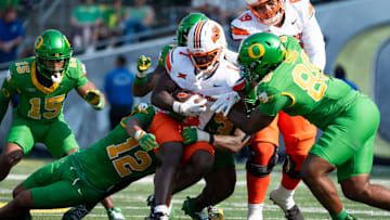 Oklahoma State running back Kalib Hicks is brought down by a pack of Oregon defenders as the Oregon Ducks host the Oklahoma State Cowboys on Sept. 6, 2025, at Autzen Stadium in Eugene, Oregon.