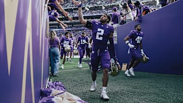 Redshirt freshman cornerback Caleb Presley slaps hands with fans.