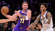 Nov 28, 2025; Los Angeles, California, USA;  Los Angeles Lakers guard Luka Doncic (77) is defended by Dallas Mavericks forward P.J. Washington (25) as he drives to the basket in the first half at Crypto.com Arena. Mandatory Credit: Jayne Kamin-Oncea-Imagn Images