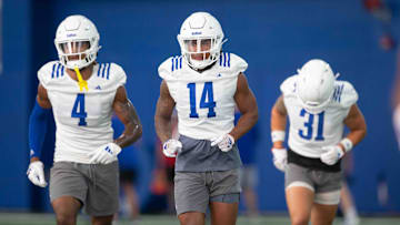 Kansas safety players, from left, redshirt senior Marvin Grant (4), redshirt junior Jalen Dye (14), and redshirt junior Landon Nelson (31) run to the next station during an indoor practice Wednesday, July 31.