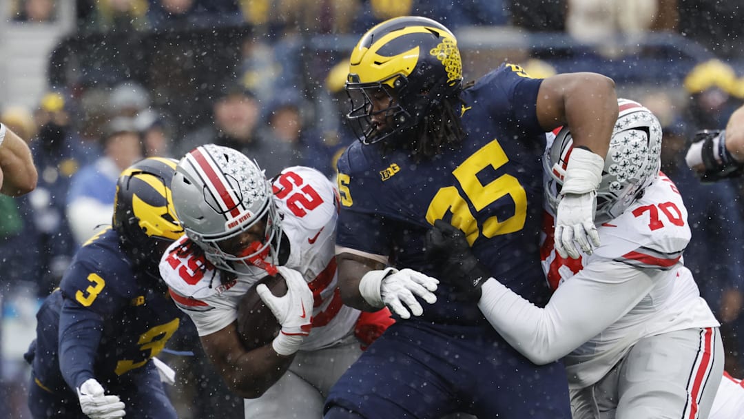 Nov 29, 2025; Ann Arbor, Michigan, USA; Ohio State Buckeyes running back Bo Jackson (25) runs the ball defended by Michigan Wolverines defensive back Jaden Mangham (3) and defensive lineman Trey Pierce (95) in the first half at Michigan Stadium. Mandatory Credit: Rick Osentoski-Imagn Images Nov 29, 2025; Ann Arbor, Michigan, USA; Ohio State Buckeyes running back Bo Jackson (25) runs the ball defended by Michigan Wolverines defensive back Jaden Mangham (3) and defensive lineman Trey Pierce (95) in the first half at Michigan Stadium. Mandatory Credit: Rick Osentoski-Imagn Images