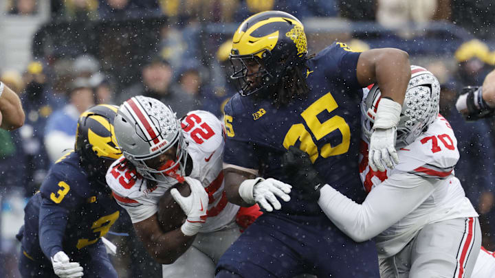 Nov 29, 2025; Ann Arbor, Michigan, USA; Ohio State Buckeyes running back Bo Jackson (25) runs the ball defended by Michigan Wolverines defensive back Jaden Mangham (3) and defensive lineman Trey Pierce (95)  in the first half at Michigan Stadium. Mandatory Credit: Rick Osentoski-Imagn Images