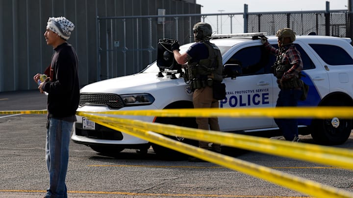 Law enforcement personnel across police tape from protesters near a rally for immigrants going to their ICE check-ins Oct. 1, 2025 at the Homeland Security Investigations office in Cedar Rapids, Iowa.