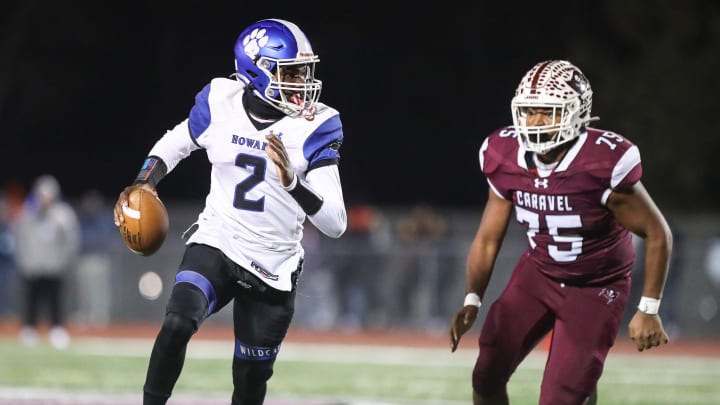 Howard senior quarterback RJ Matthews is chased by Caravel senior lineman Priest Jones in the Buccaneers    36-0 win over the Wildcats, Friday, Nov. 24, 2023 in a Class 2A DIAA football semifinal at Bob Peoples Stadium.