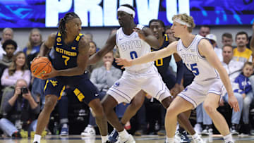 Mar 1, 2025; Provo, Utah, USA; West Virginia Mountaineers guard Javon Small (7) looks for a play against Brigham Young Cougars forward Mawot Mag (0) and forward Richie Saunders (15) during the first half at Marriott Center. Mandatory Credit: Rob Gray-Imagn Images