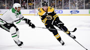 Oct 24, 2024; Boston, Massachusetts, USA;  Boston Bruins center Trent Frederic (11) controls the puck while Dallas Stars defenseman Mathew Dumba (3) defends during the first period at TD Garden. Mandatory Credit: Bob DeChiara-Imagn Images