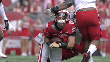 Sep 20, 2025; Madison, Wisconsin, USA; Wisconsin Badgers quarterback Danny O'Neil (18) is sacked by Maryland Terrapins linebacker Daniel Wingate (1) during the second quarter at Camp Randall Stadium. Mandatory Credit: Mark Hoffman/USA Today Network via Imagn Images