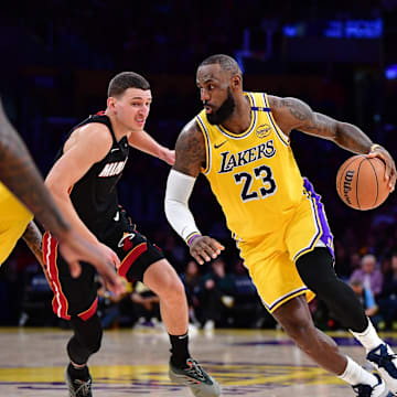 January 15, 2025; Los Angeles, California, USA; Los Angeles Lakers forward LeBron James (23) moves the ball against Miami Heat guard Tyler Herro (14) during the second half at Crypto.com Arena. Mandatory Credit: Gary A. Vasquez-Imagn Images